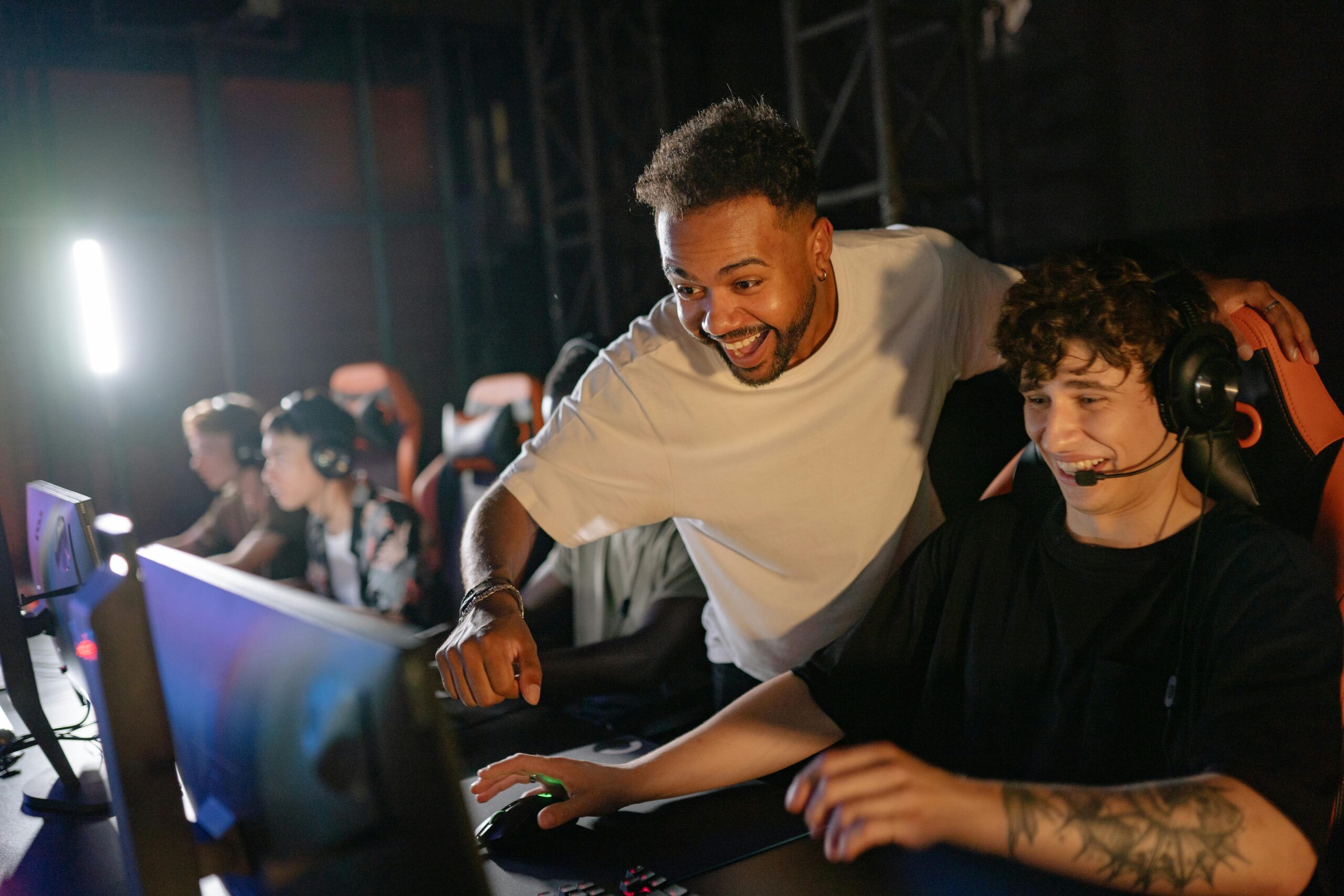 Gamers in a high-energy tournament setting enjoy competitive play with enthusiasm and teamwork.